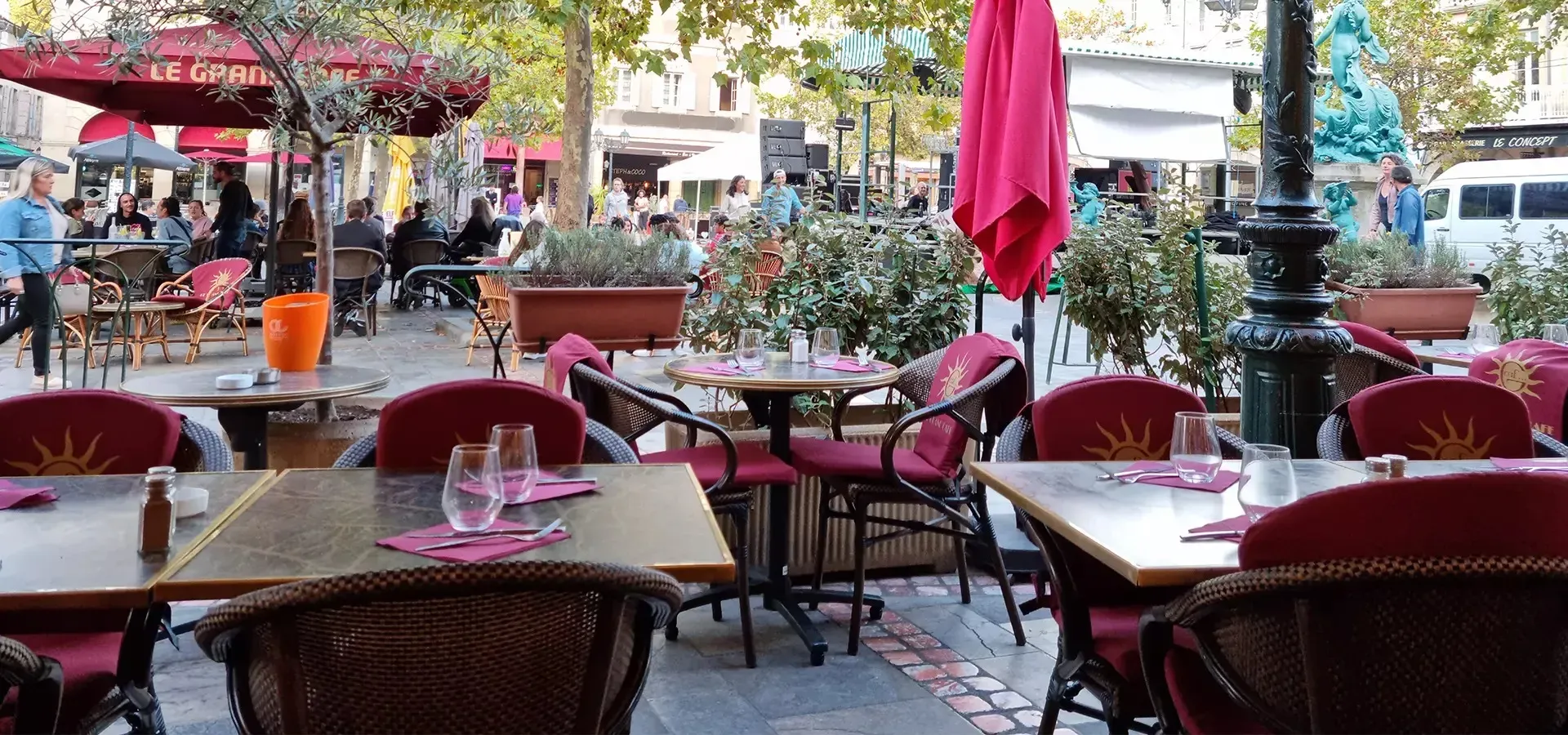 Le Grand Café terrace on the square in Limoux, with red chairs and umbrellas