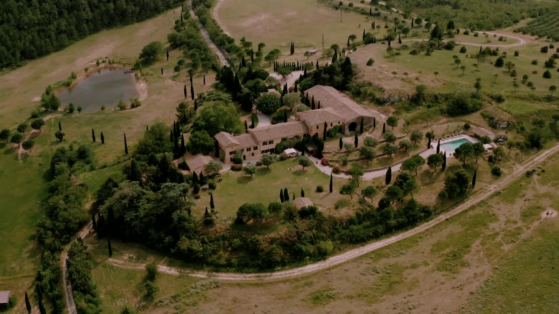 Aerial view of Domaine de la Vène: the stone house, pool and cypress-lined grounds in the Corbières hills